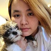 Champ joined the competition — help win amazing prizes! person, dog, puppy, close_up, selfie, indoor, face, hair, white_shirt, hand, cute, fluffy, pet, animal, portrait, young_adult, light, skin, expression, holding