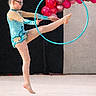 child, gymnast, gymnastics, leotard, hoop, balloons, performance, sport, flexibility, balance, indoor, young_girl, athlete, pose, floor, costume, event, competition, dance, motion