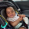 baby, car_seat, child, smiling, tongue_out, plush_toy, unicorn, toy, car_interior, seatbelt, window, greenery, hand, sock, clothing, person, cute, infant, happy, travel