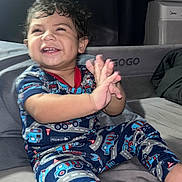 Roberto joined the competition — help win amazing prizes! toddler, child, pajamas, clapping, smiling, indoor, bed, happy, person, young_child, curly_hair, playpen, fabric, footwear_free, couch, furniture, room, home, cute, portrait