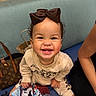 toddler, child, smiling, bow, headband, sitting, bench, cushion, clothing, happy, person, bag, handbag, patterned_blanket, indoor, portrait, cute, fashion, baby, casual