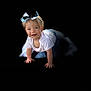 Barbara is registered to the contest to win money with this photo: toddler, child, baby, crawling, headband, bow, white_shirt, blue_skirt, smiling, happy, portrait, isolated, black_background, cute, young_child, small_hands, blond_hair, blue_eyes, studio_style, playful