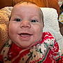 baby, smiling, face, closeup, blanket, red, green, white, pattern, cozy, indoor, infant, cute, happy, person, plush, texture, soft, portrait, child