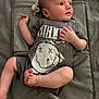 baby, infant, child, tshirt, nirvana, smiley_face, lying_down, mat, padded_mat, barefoot, skin, head, arms, legs, hand, foot, face, looking_away, clothing, indoors