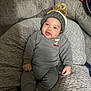 baby, blanket, child, clothing, comfort, cozy, cushion, cute, expression, face, gray, hat, indoors, infant, knit_hat, person, pom_pom, seated, smile, soft