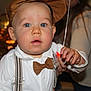 baby, child, face, blue_eyes, cap, bow_tie, suspenders, white_shirt, hand, string, indoor, portrait, person, cute, closeup, curious, infant, fashion, people, background_blur