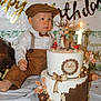 Paolo participe au concours pour gagner de l'argent avec cette photo : toddler, birthday_cake, deer_figurine, number_one_candle, brown_clothing, suspenders, birthday_banner, party, celebration, tablecloth, decorations, child, hat, cake_topper, candles, indoor, portrait, festive, cute, smiling