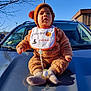 autumn, baby, bib, blue_sky, car, child, costume, cute, daylight, expression, fuzzy_clothing, halloween, hat, hood, infant, outdoor, pacifier, person, seasonal, socks