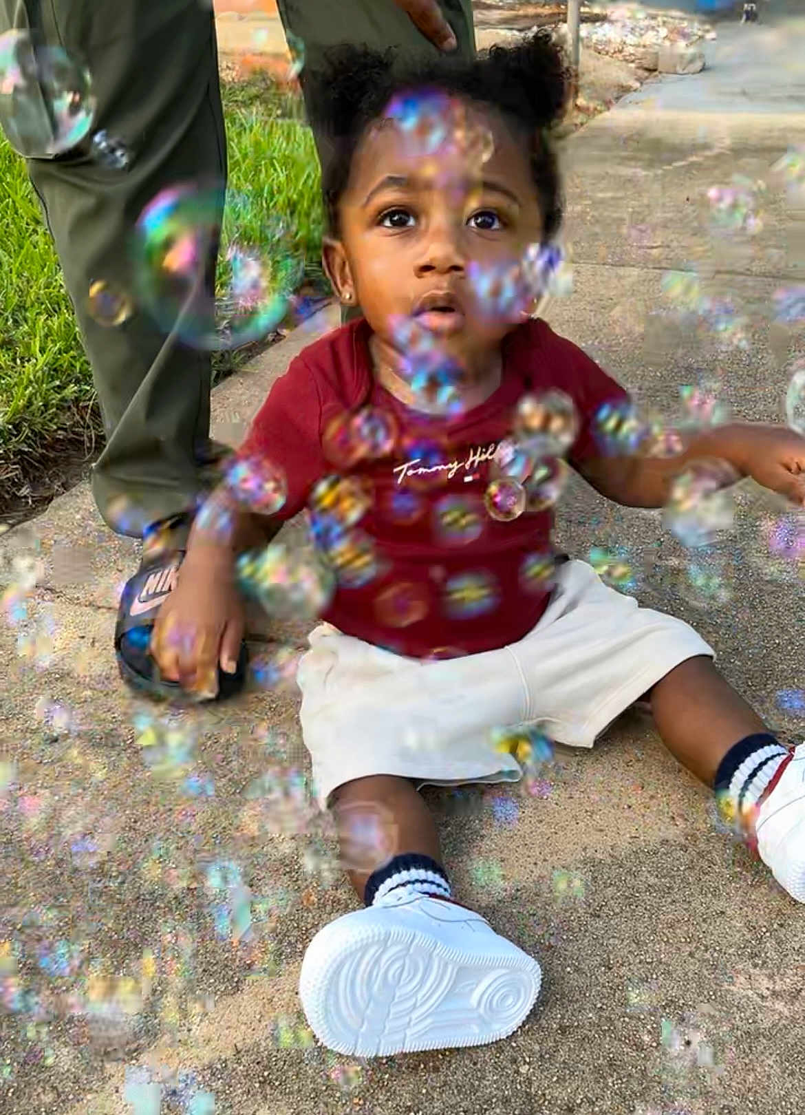 Tamir joined the competition — help win amazing prizes! toddler, child, bubbles, outdoor, sidewalk, grass, person, footwear, white_shoes, socks, shorts, tshirt, curly_hair, hand, adult, summer, play, fun, casual, nature