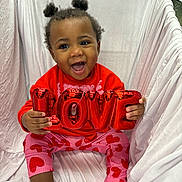 Elizabelle joined the competition — help win amazing prizes! toddler, child, smiling, love, balloon, red_sweater, pink_pants, heart_pattern, socks, indoor, white_background, happy, cute, portrait, seated, baby, puffy_hair, playful, colorful_clothing, joyful