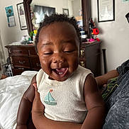 Xzavier is registered to the contest to win money with this photo: arm, baby, bed, blanket, child, cute, dresser, furniture, hand, happy, holding, home, indoor, knit_clothing, laughing, mirror, person, sailboat_design, sleeveless, smiling