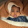Foulaydi participe au concours pour gagner de l'argent avec cette photo : baby, infant, face, expression, tongue_out, blanket, hood, warm_clothing, jacket, fur_lining, brown, cozy, cute, portrait, child, closeup, indoor, person, knit, texture