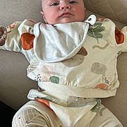 Spencer is registered to the contest to win money with this photo: baby, bib, child, clothing, couch, cozy, cute, fabric, face, head, indoor, infant, legs, pattern, person, sitting, skin, socks, soft, young
