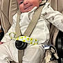 baby, infant, car_seat, smile, white_clothing, straps, pacifier_clip, sock, cute, indoors, child, seat_belt, sitting, happy, face, person, soft_fabric, comfort, young_child, portrait