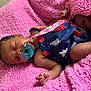 Daja is registered to the contest to win money with this photo: baby, sleeping, pacifier, blanket, pink, navy_blue, clothing, infant, cute, cozy, soft_texture, peaceful, resting, child, newborn, wrapped, relaxing, indoor, portrait, hand
