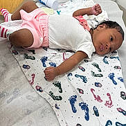 Daja joined the competition — help win amazing prizes! baby, infant, hospital, blanket, pattern, footwear, socks, clothing, person, medical, laying_down, curious, newborn, pink, white, striped, skin, face, arm, indoors