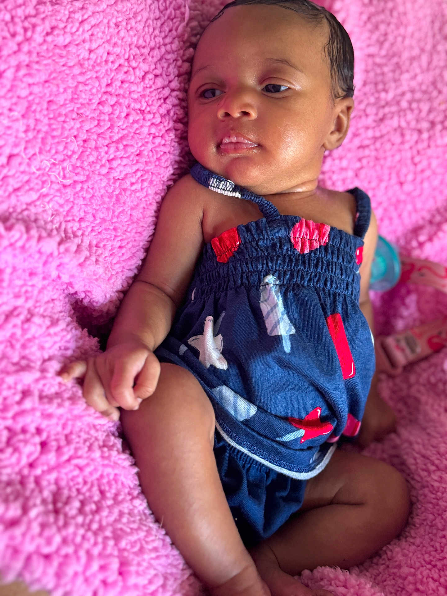 Daja joined the competition — help win amazing prizes! baby, infant, child, pink_blanket, blue_outfit, red_accents, lying_down, curious_expression, soft_texture, skin, face, hand, legs, sleepwear, indoors, cozy, cute, portrait, newborn, toddler