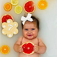 Mélia participe au concours pour gagner de l'argent avec cette photo : baby, infant, citrus, grapefruit, orange, lemon, milky_bath, bow, smile, happy, hand, skin, cute, floating, fruit_slice, wooden_sign, milestone, portrait, water, child