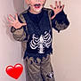child, corner, excited, face_paint, halloween, hands, heart_sticker, indoor, kid, makeup, open_mouth, playful, portrait, pose, shoes, skeleton_costume, smile, tiles, wall, young_person