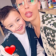 Nyno a rejoint le concours — aidez-le/la à gagner de superbes lots ! adult, child, close_up, countertop, face, family, glasses, glasses_reflection, heart_sticker, indoor, jacket, kitchen, playful, portrait, selfie, short_hair, smiling, sweater, table, tongue_out
