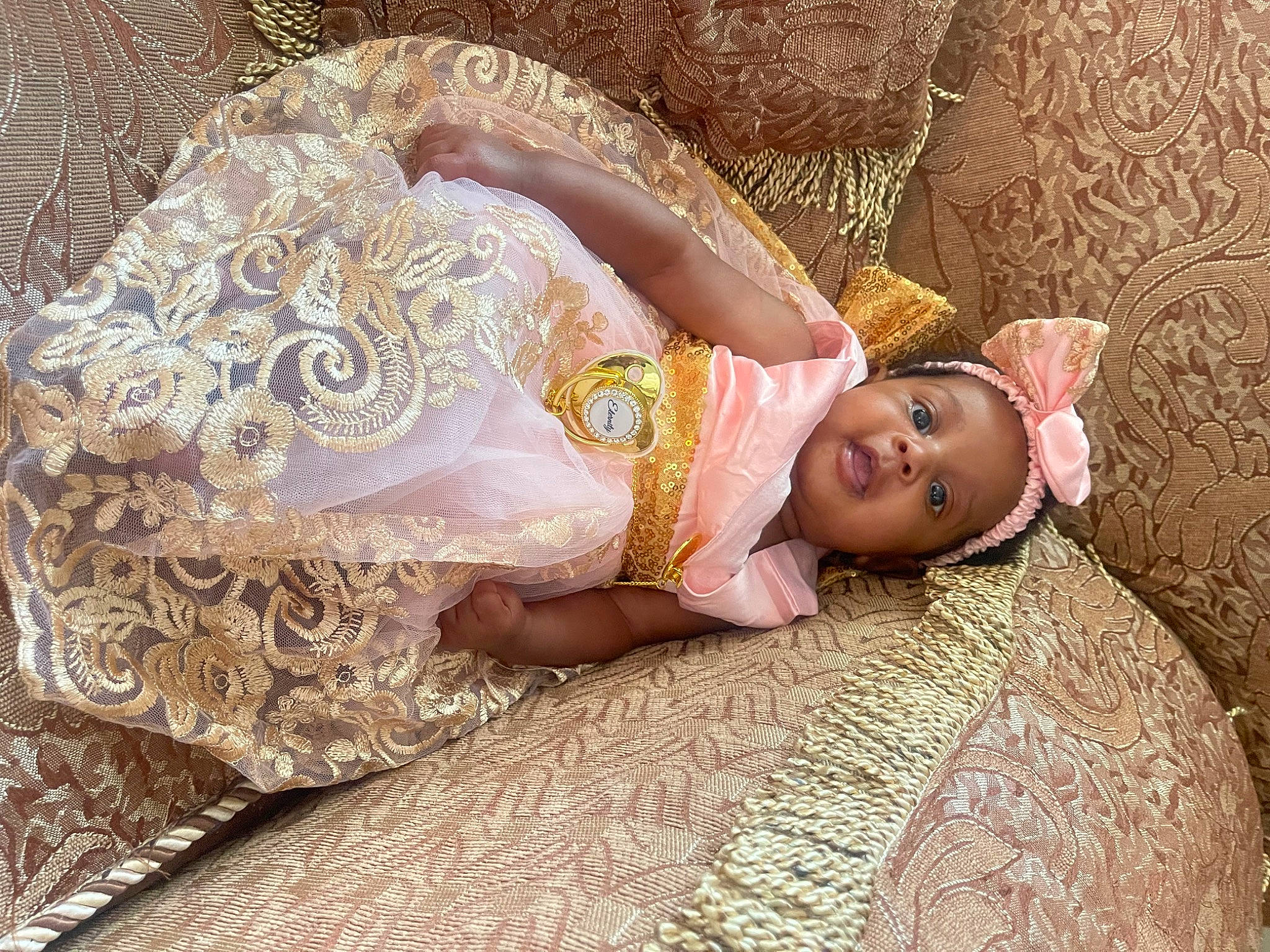 Eternity is registered to the contest to win money with this photo: baby, comfort, dress, embellishment, eye, fawn, flooring, happy, head, headpiece, human_body, jewellery, linens, pattern, person, plant, skin, textile, toddler, tree