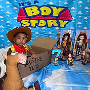 Asher Javier joined the competition — help win amazing prizes! toddler, child, toy_story, woody, jessie, bullseye, toy, cardboard_box, birthday_candle, birthday, cowboy_hat, red_bandana, blue_backdrop, cloud_pattern, smiling_child, indoor, celebration, birthday_party, person, toys
