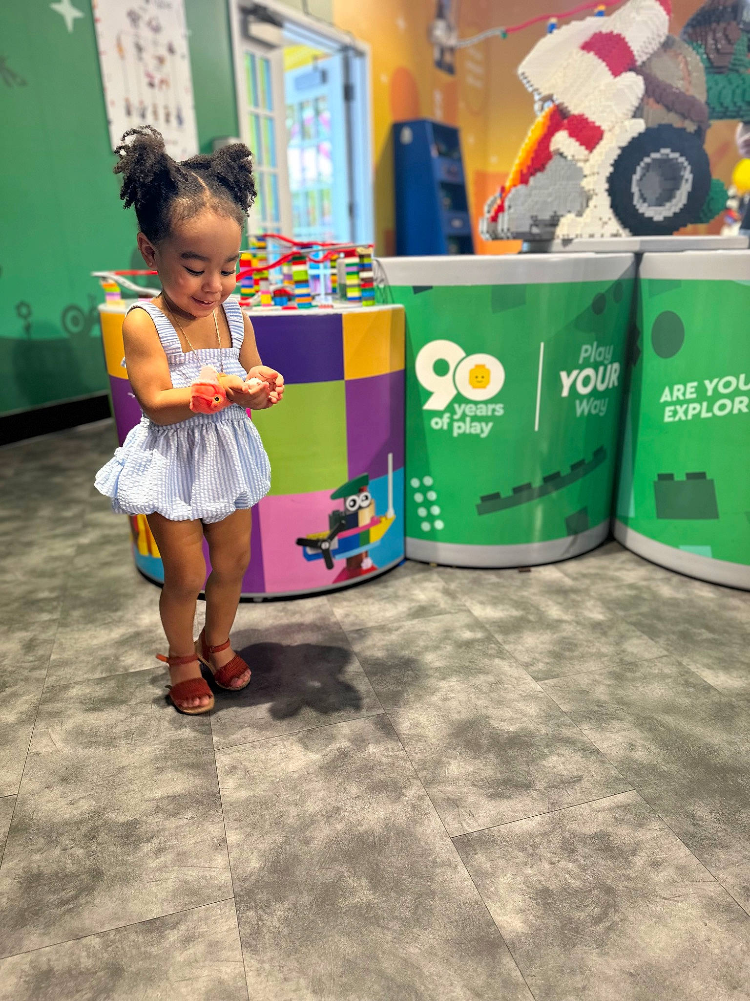 Heaven is registered to the contest to win money with this photo: asphalt, child, city, event, flooring, fun, green, happy, joy, leisure, machine, motorcycle, person, plastic, recreation, sandal, soil, street, tire, toddler