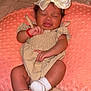 baby, infant, bow, headwear, sock, hand, pillow, blanket, bed, sleepwear, cute, child, person, skin, expression, resting, soft_texture, indoor, comfort, toddler