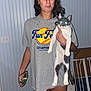 baby_gate, blue_wall, bracelet, casual, cat, curly_hair, earrings, expression, flash, floor, glowing_eyes, gray_tshirt, holding, home, indoor, light_switch, pet, phone, standing, woman
