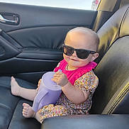 Zena Kay Balch joined the competition — help win amazing prizes! baby, sunglasses, car_seat, leather, watering_can, floral_dress, pink, child, smile, cute, summer, sunlight, portrait, indoors, seat, foot, hand, toy, cool, happy