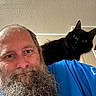 animal, beard, black_cat, blue_shirt, casual, cat, ceiling, closeup, companion, expression, friendship, fur, human, indoor, man, pet, portrait, shoulder, texture, wide_eyes