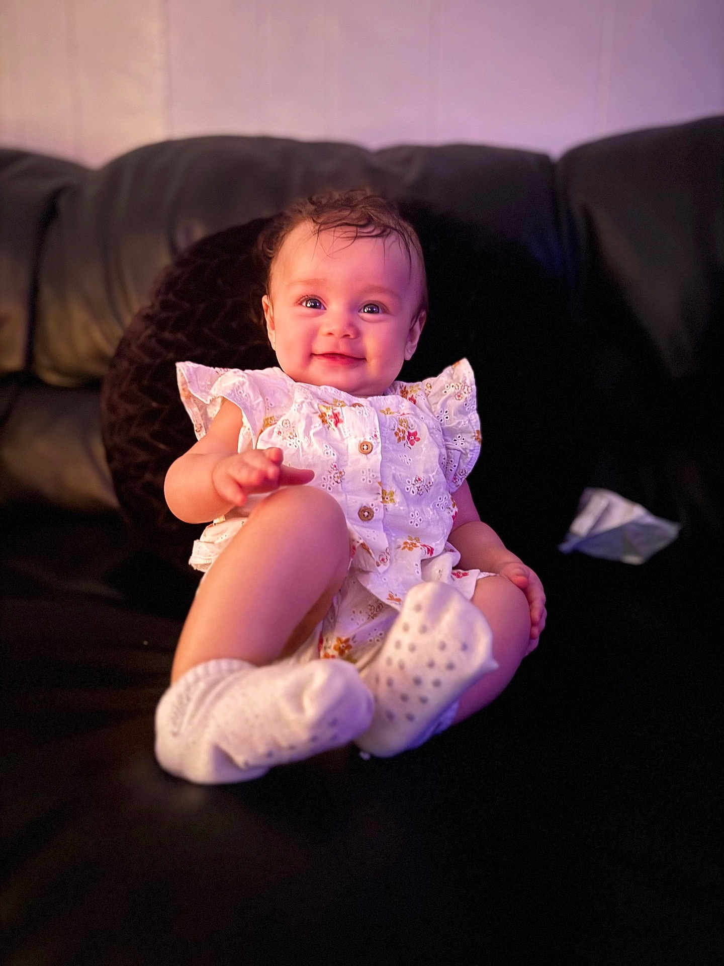 Alyssa joined the competition — help win amazing prizes! baby, infant, smile, couch, white_clothing, socks, happy, child, indoor, cute, portrait, people, sitting, young_child, cozy, relaxing, expression, warm_lighting, home, comfort