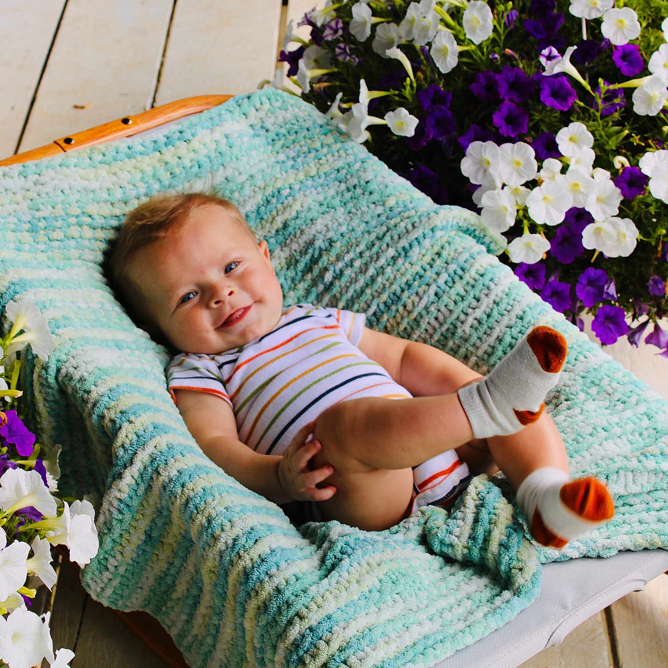 Beau is registered to the contest to win money with this photo: baby, blanket, clothing, cushion, face, flower, flowerarrangement, flowerbouquet, furniture, geranium, head, homedecor, hosiery, person, petal, photography, plant, portrait, purple, sock