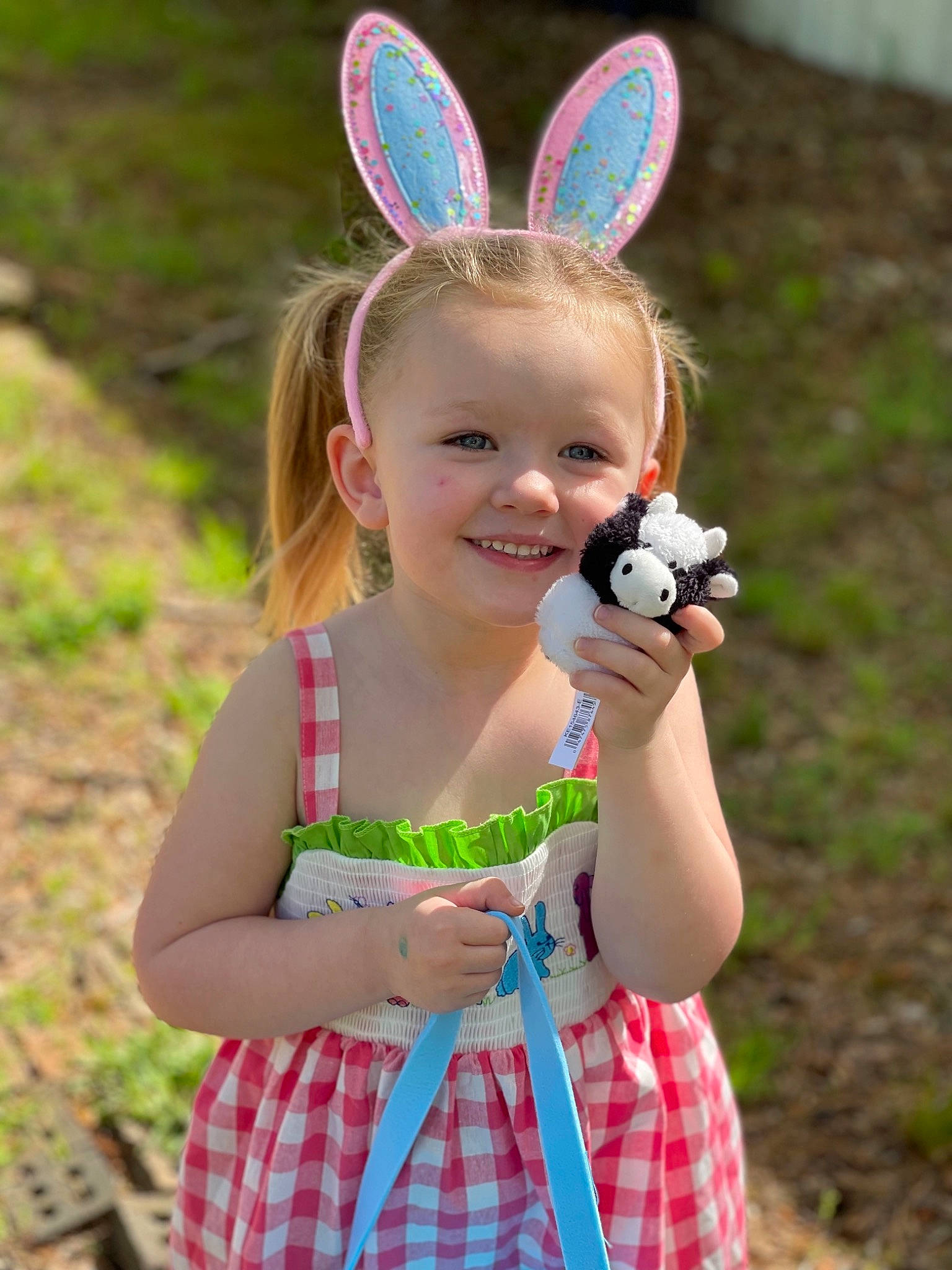 Ava is registered to the contest to win money with this photo: baby_toddler_clothing, child, face, finger, fun, grass, happy, joy, leaf, nature, people_in_nature, person, photograph, pink, plaid, plant, skin, smile, summer, tartan