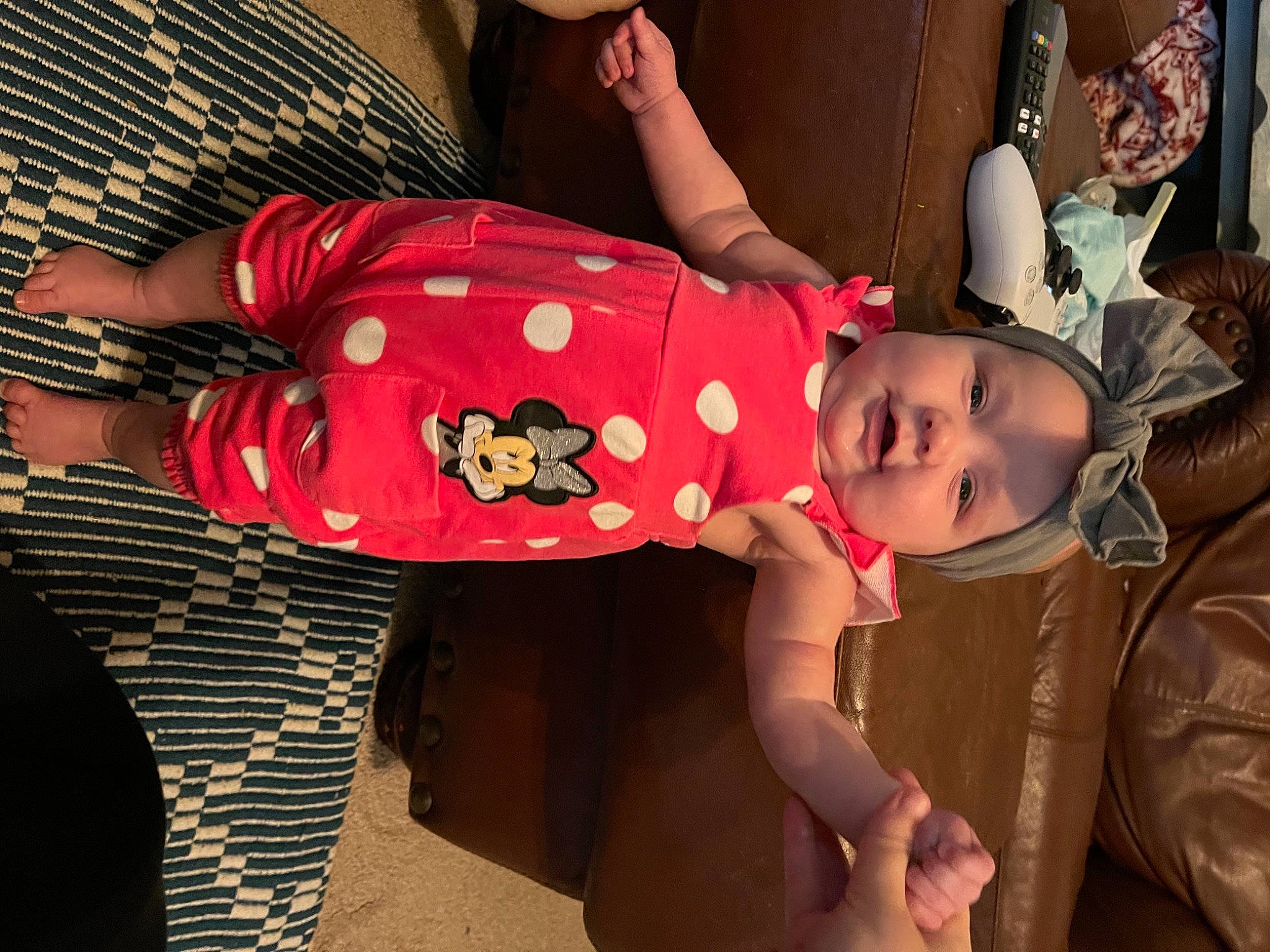 Meredith is registered to the contest to win money with this photo: arm, baby, baby_toddler_clothing, black_hair, child, comfort, event, facial_expression, fun, happy, hat, headgear, headwear, human_body, human_leg, pattern, person, pink, thigh, toddler