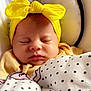 baby, sleeping, blanket, headband, yellow, polka_dot, bow, face, infant, cozy, cute, child, soft, closeup, indoor, rest, peaceful, apparel, person, newborn
