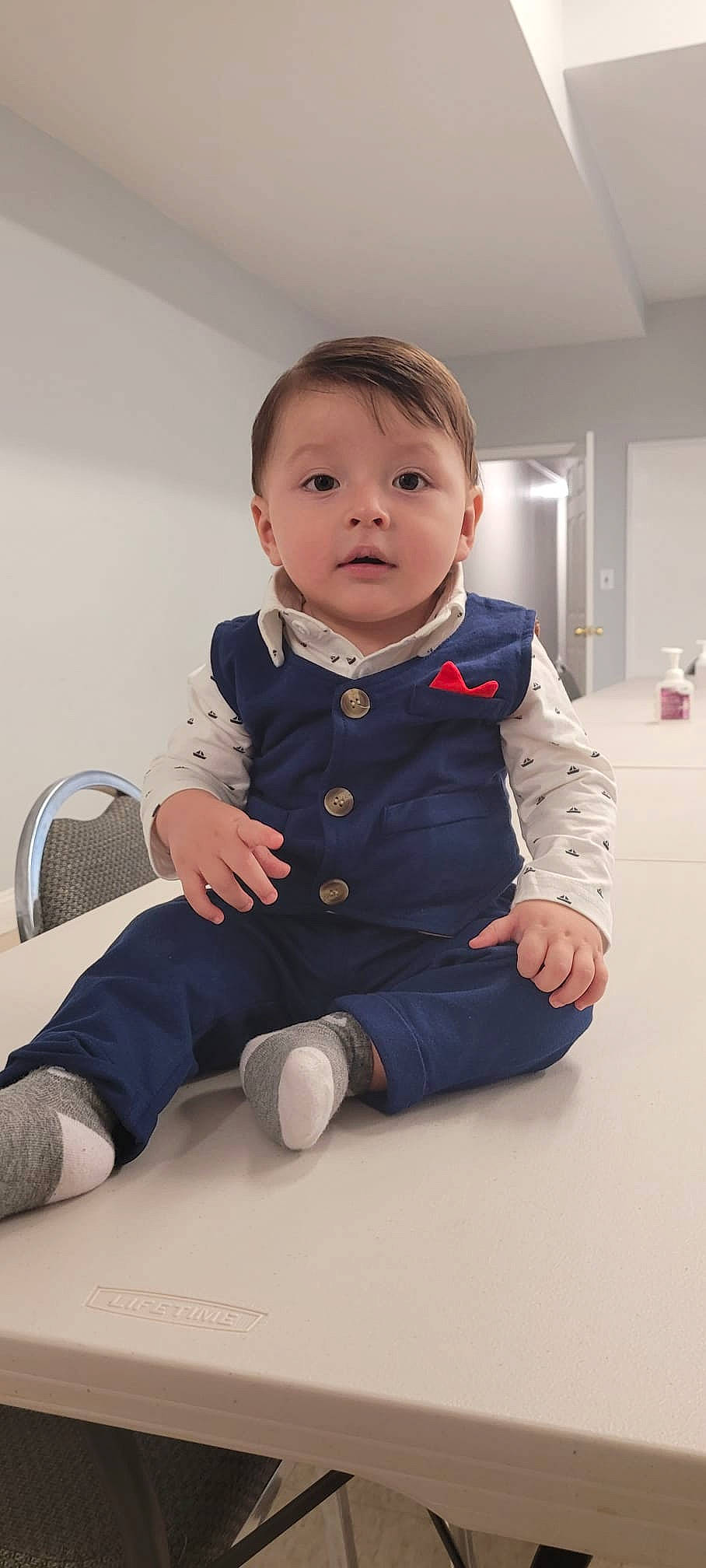 Jared is registered to the contest to win money with this photo: baby, baby_toddler_clothing, cheek, child, collar, comfort, elbow, flooring, foot, happy, human_leg, knee, long_sleeved_t_shirt, person, room, sitting, skin, sleeve, sock, thumb