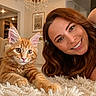 Daisy joined the competition — help win amazing prizes! woman, cat, orange_tabby, carpet, indoor, portrait, smiling, fluffy, chandelier, hair, furniture, home, pet, cozy, face, eyes, fur, relaxing, cute, animal