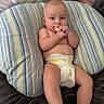 baby, diaper, cushion, striped, baby_food, chewing, infant, person, tattoo, arm, blanket, bed, skin, hand, foot, indoor, closeup, cute, resting, comfort