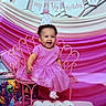 Sevyn joined the competition — help win amazing prizes! baby, infant, child, birthday, half_birthday, party_hat, pink_dress, smiling, sitting, chair, portrait, indoors, celebration, decorations, streamers, backdrop, gift_box, cartoon, numbers, happy