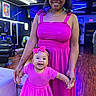 Sevyn is registered to the contest to win money with this photo: baby, child, mother, adult, smiling, portrait, pink_clothing, bow, dress, matching_outfits, family, salon, hair_salon, indoor, neon_lighting, blue_lighting, wood_floor, chairs, happy, photography