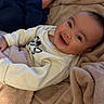 Haisley is registered to the contest to win money with this photo: baby, blanket, bottle, child, cozy, cute, face, happy, indoors, infant, laying, light, person, portrait, smiling, toddler, warm, wearing, white_clothing, blue_clothing