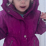 Alivia is registered to the contest to win money with this photo: toddler, child, winter_clothing, coat, hat, pink_hat, magenta_coat, snow, outdoor, cold_weather, blue_eyes, face, young_child, curious_expression, standing, zipper, button, knit_hat, winter, person