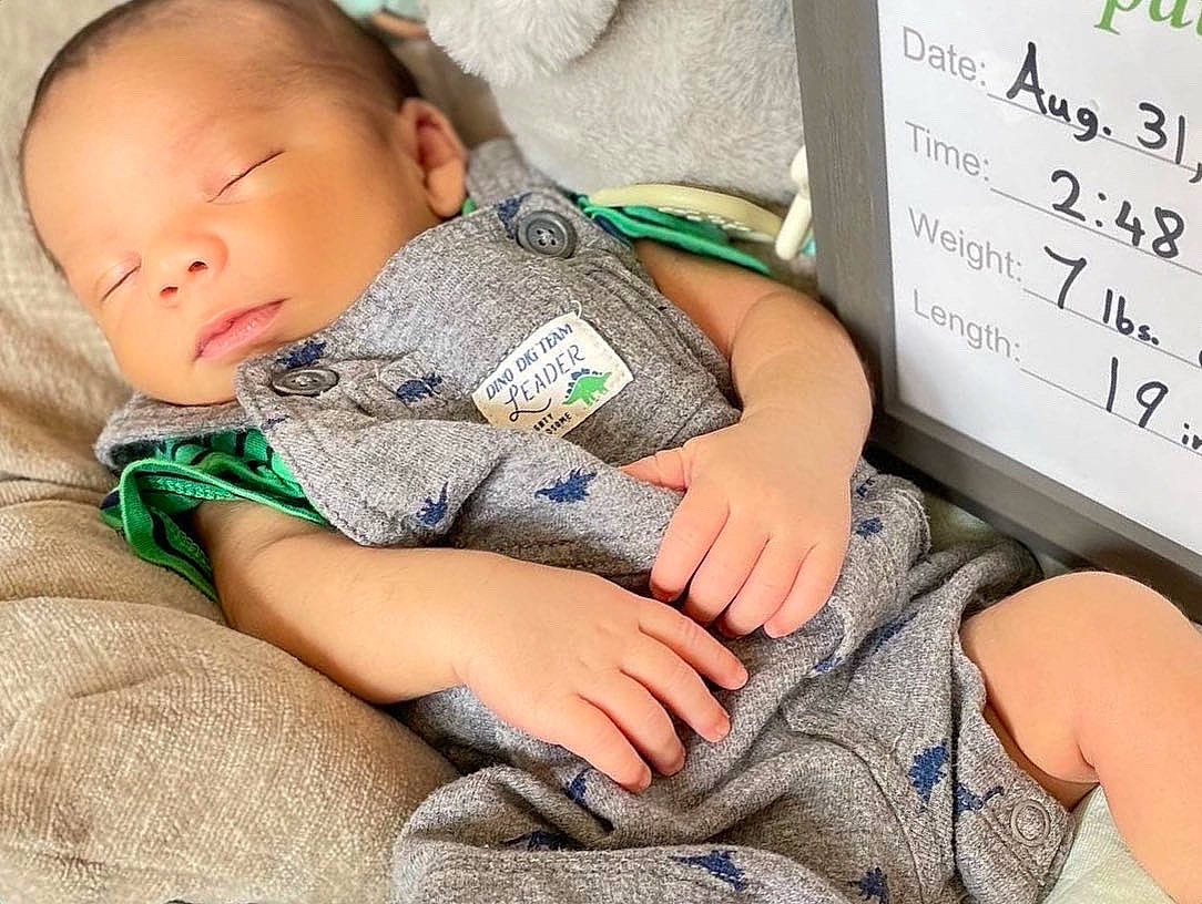 Elijah is registered to the contest to win money with this photo: arm, baby, baby_products, baby_sleeping, baby_toddler_clothing, child, comfort, finger, grass, hand, human_body, human_leg, knee, mammal, person, room, sitting, skin, thigh, toddler