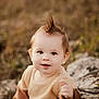 Wes is registered to the contest to win money with this photo: baby, child, outdoor, nature, grass, log, hairstyle, mohawk, sweater, jeans, cute, smiling, portrait, young, person, fall, season, happy, sitting, curious