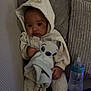 Loyal a rejoint le concours — aidez-le/la à gagner de superbes lots ! baby, hoodie, plush_toy, couch, pillow, bottle, socks, infant, clothing, indoor, child, cute, soft_toy, seated, comfort, relaxation, young_child, face, hand, footwear