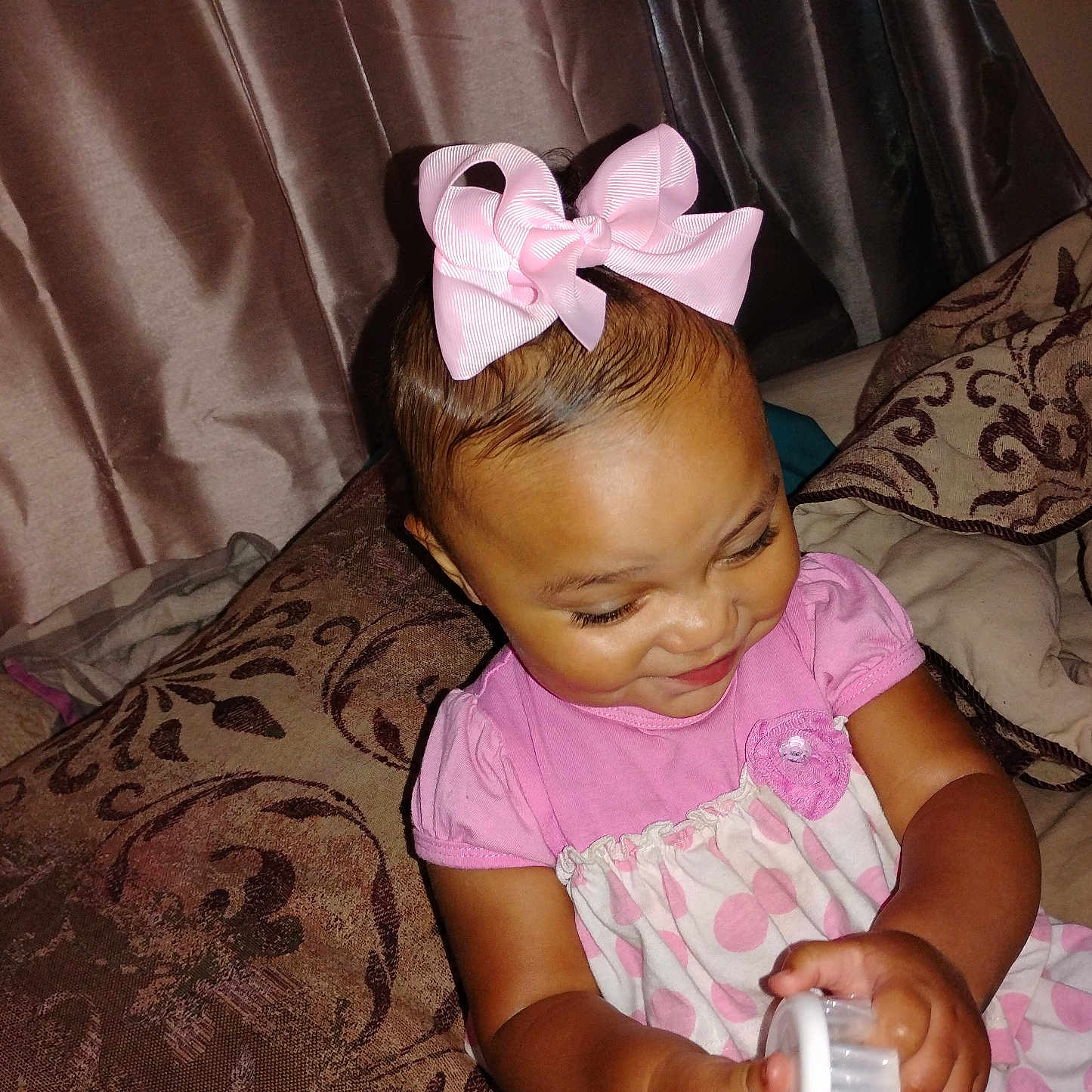 Myla joined the competition — help win amazing prizes! baby, child, closeup, curtains, cute, fabric, face, hand, happy, home, indoors, person, pillows, pink_bow, playing, polka_dot_dress, seated, smiling, toddler, toy