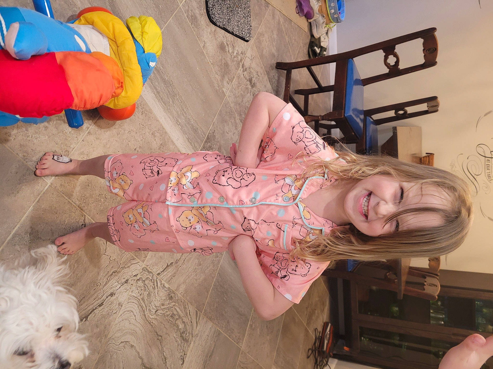 Charleigh is registered to the contest to win money with this photo: child, companion_dog, dog, flooring, fun, happy, human_leg, joy, leisure, linens, magenta, pattern, person, pink, room, skin, small_terrier, smile, terrier, textile