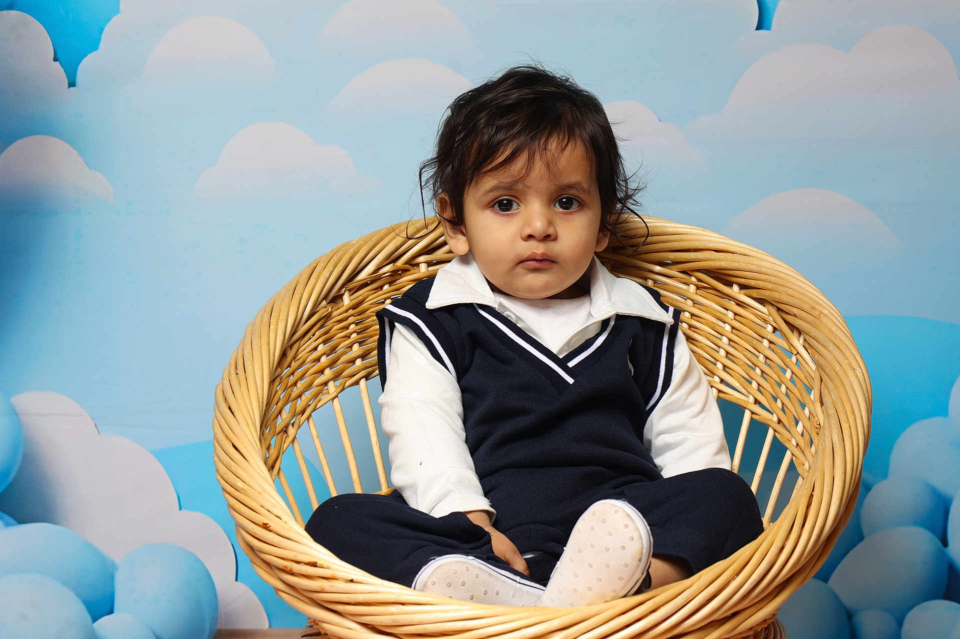 Gurniwaz joined the competition — help win amazing prizes! toddler, child, wicker_chair, blue_background, clouds, indoor, portrait, serious_expression, clothing, navy_sweater, white_shirt, footwear, baby, cute, sitting, furniture, person, studio, photography, young_child