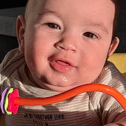 Matteo joined the competition — help win amazing prizes! baby, child, infant, portrait, close_up, face, smiling, happy, eyes, drooling, toy, orange_toy, pacifier, clothing, onesie, sitting, indoor, warm_lighting, photography, cute